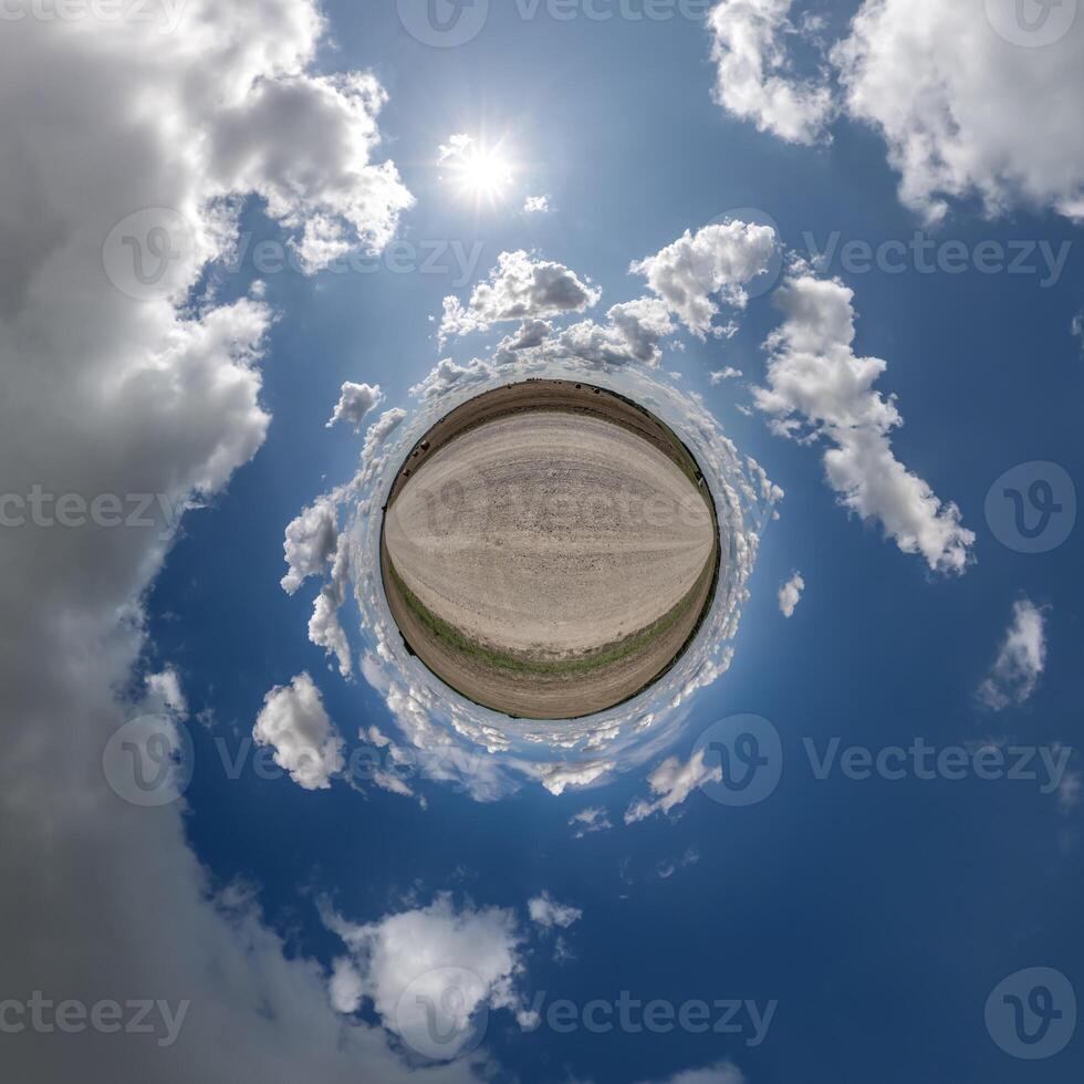 simple green tiny planet without buildings in blue sky with beautiful clouds. Transformation of spherical panorama 360 degrees. Spherical abstract aerial view. Curvature of space. photo