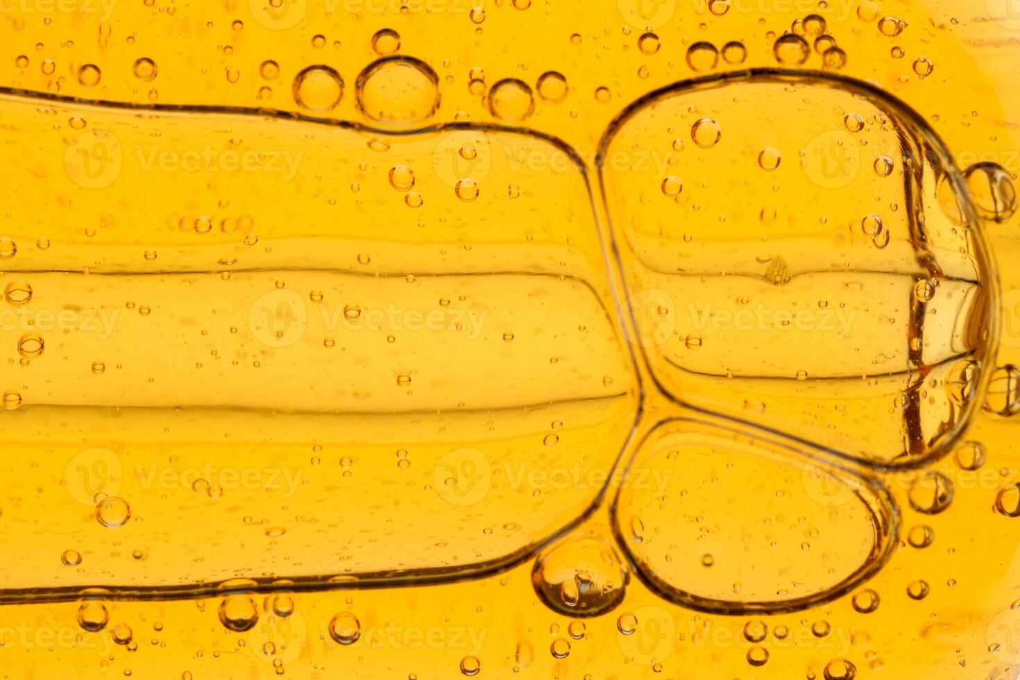 Golden yellow abstract oil bubbles or face serum background. Oil bubbles macro photography. photo