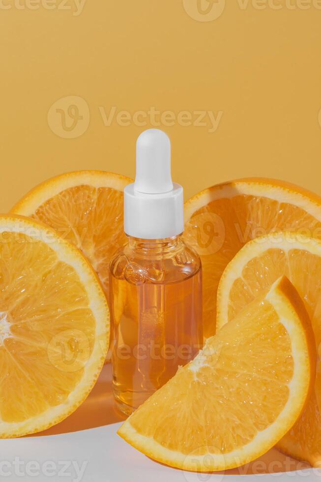 un brillante y refrescante monitor de un vitamina C suero botella junto a Fresco naranja rebanadas en naranja antecedentes. protección de la piel foto