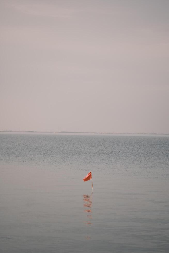 Calm water and red flag photo