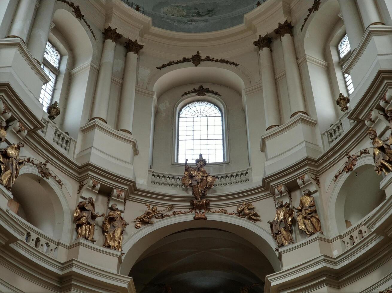 Gold and bronze antique statues under the dome of the cathedral photo