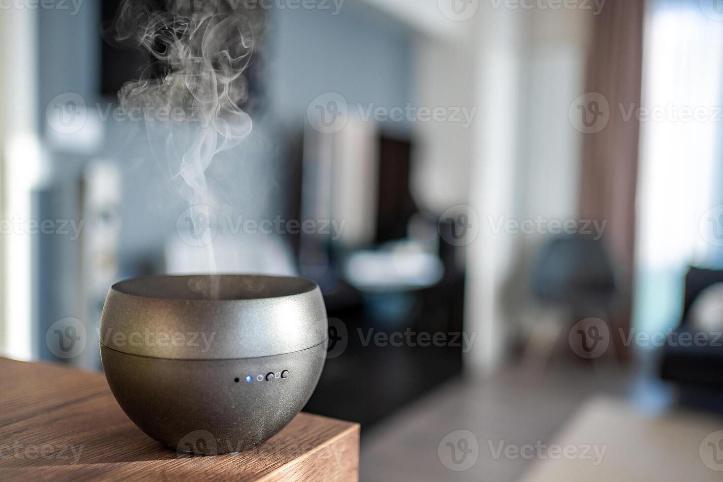 Grey aroma oil diffuser on light table at home, space for text. Air freshener photo