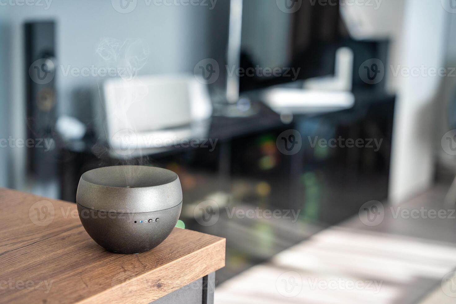 Grey aroma oil diffuser on light table at home, space for text. Air freshener photo