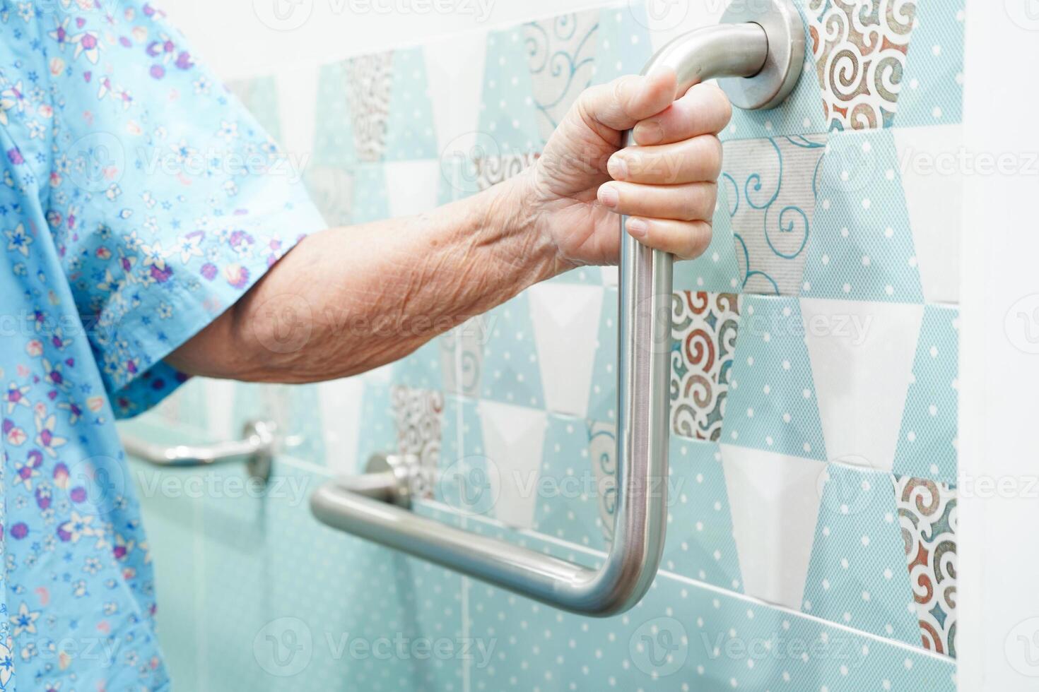 Asian elderly old woman patient use toilet support rail in bathroom, handrail safety grab bar, security in nursing hospital. photo