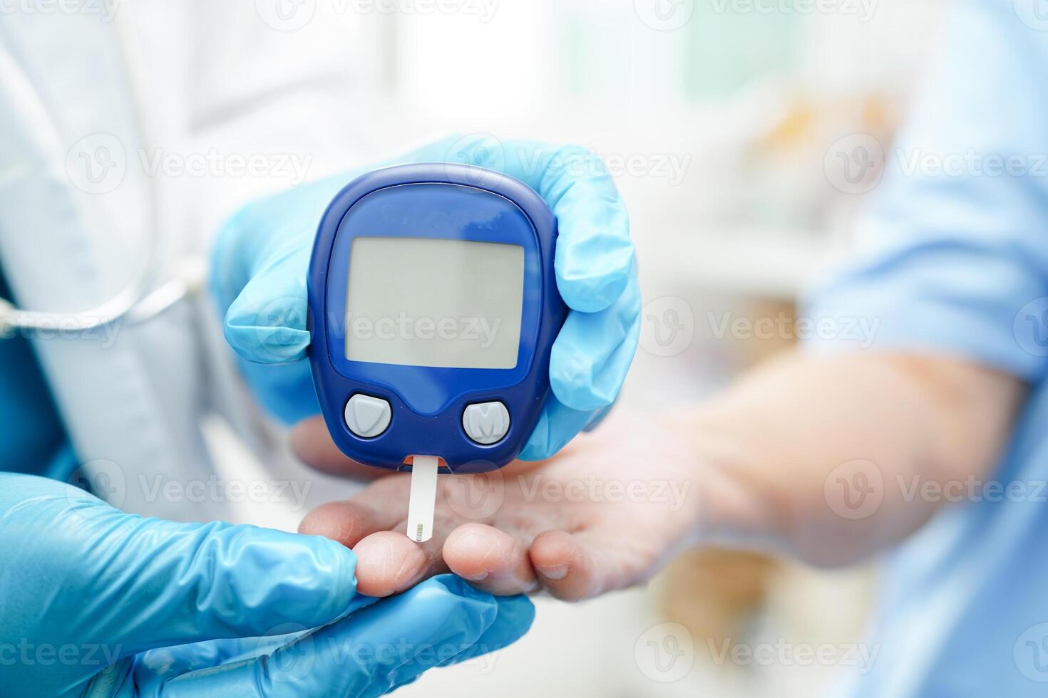 Asian doctor using digital glucose meter for check sample blood sugar level to treatment diabetes. photo