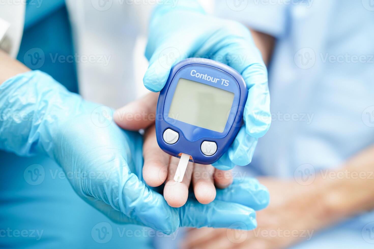 Asian doctor using digital glucose meter for check sample blood sugar level to treatment diabetes. photo