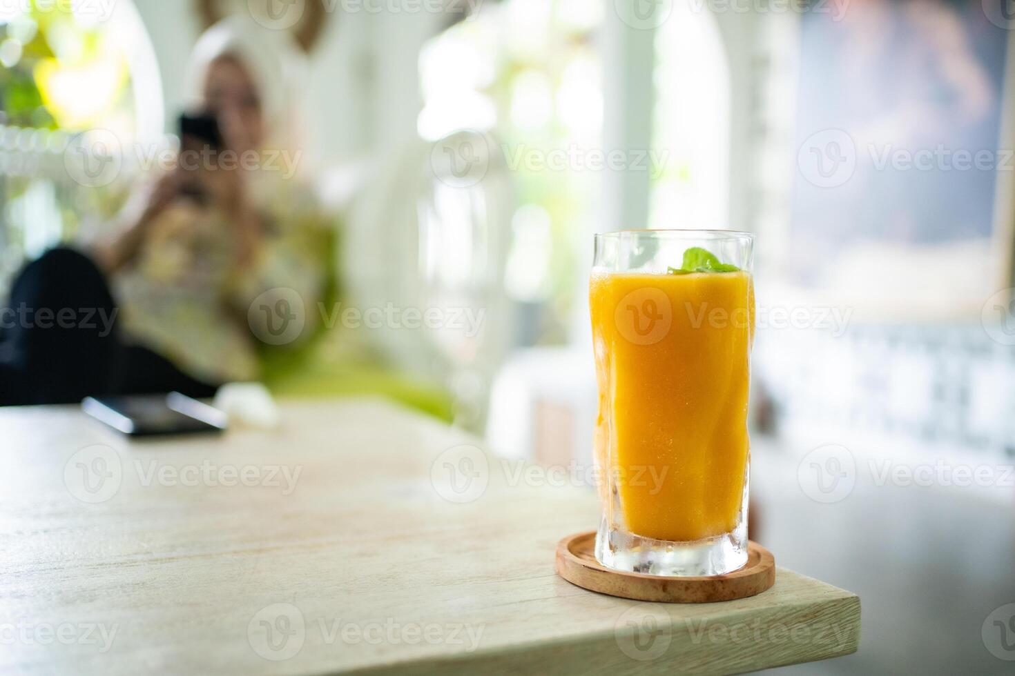 Fresh mango juice on table with luxury home blur background photo
