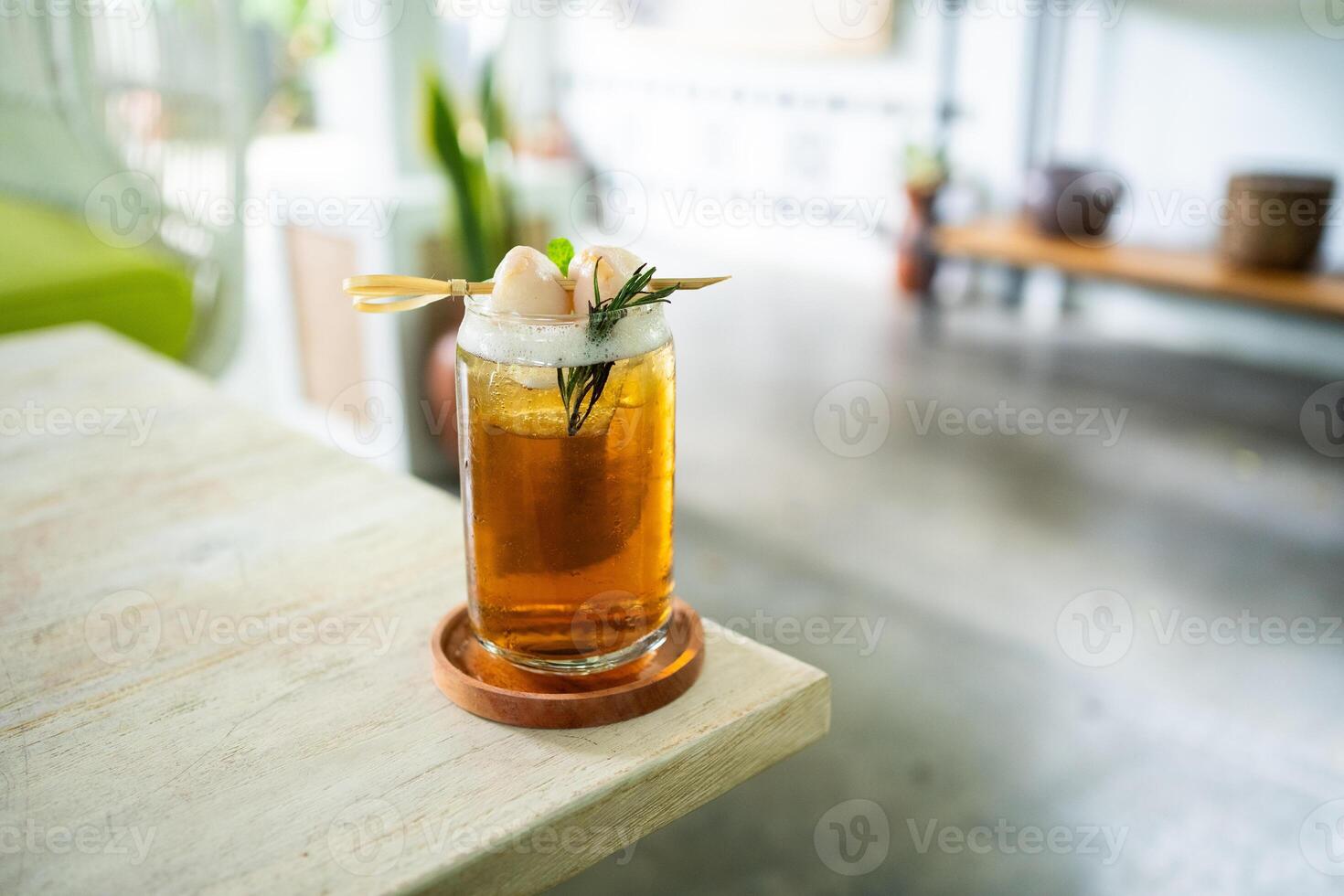 Fresh cold drink of lychee tea on a table with an elegant cafe in the background. photo