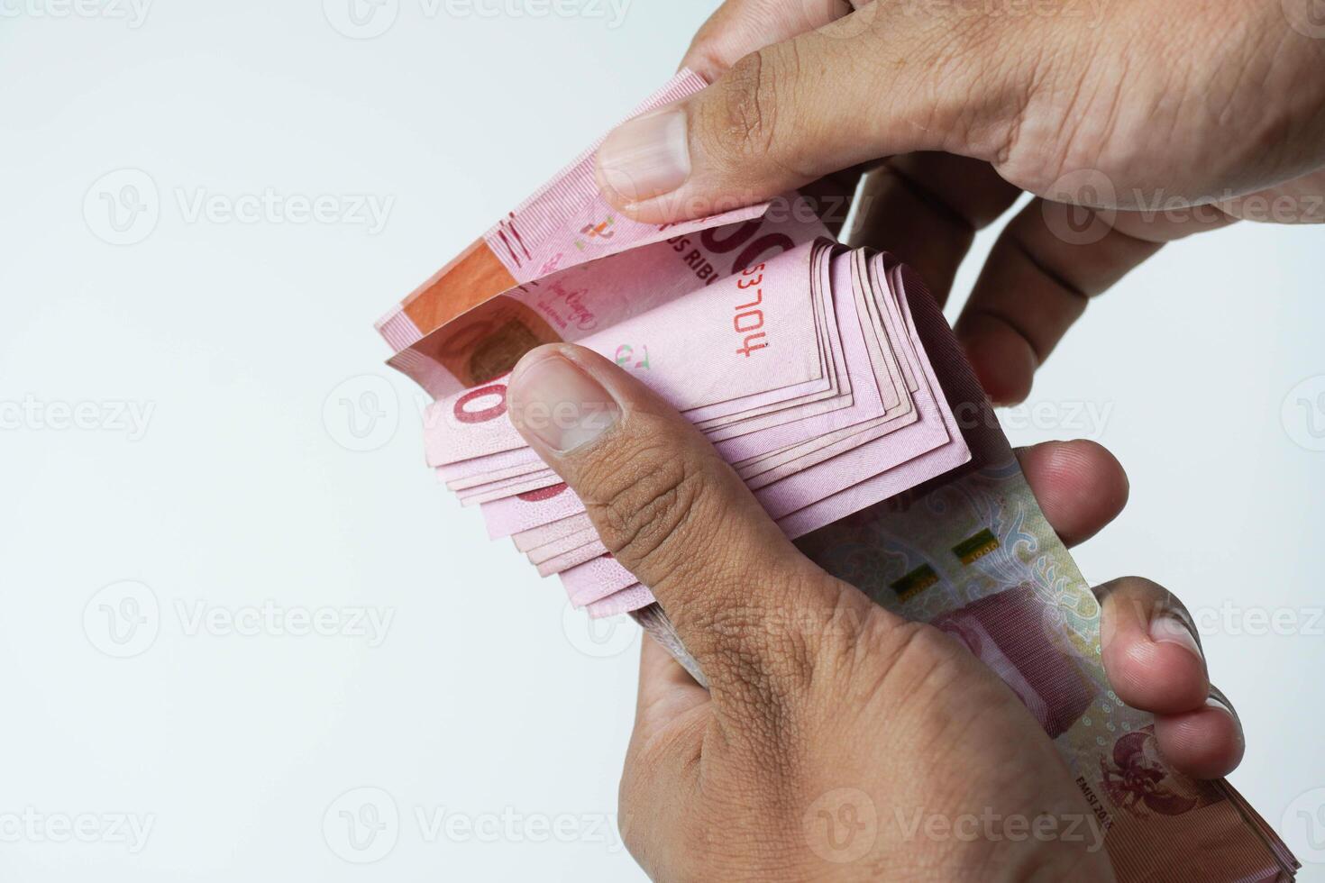 the process of counting Indonesian rupiah money on a white background photo
