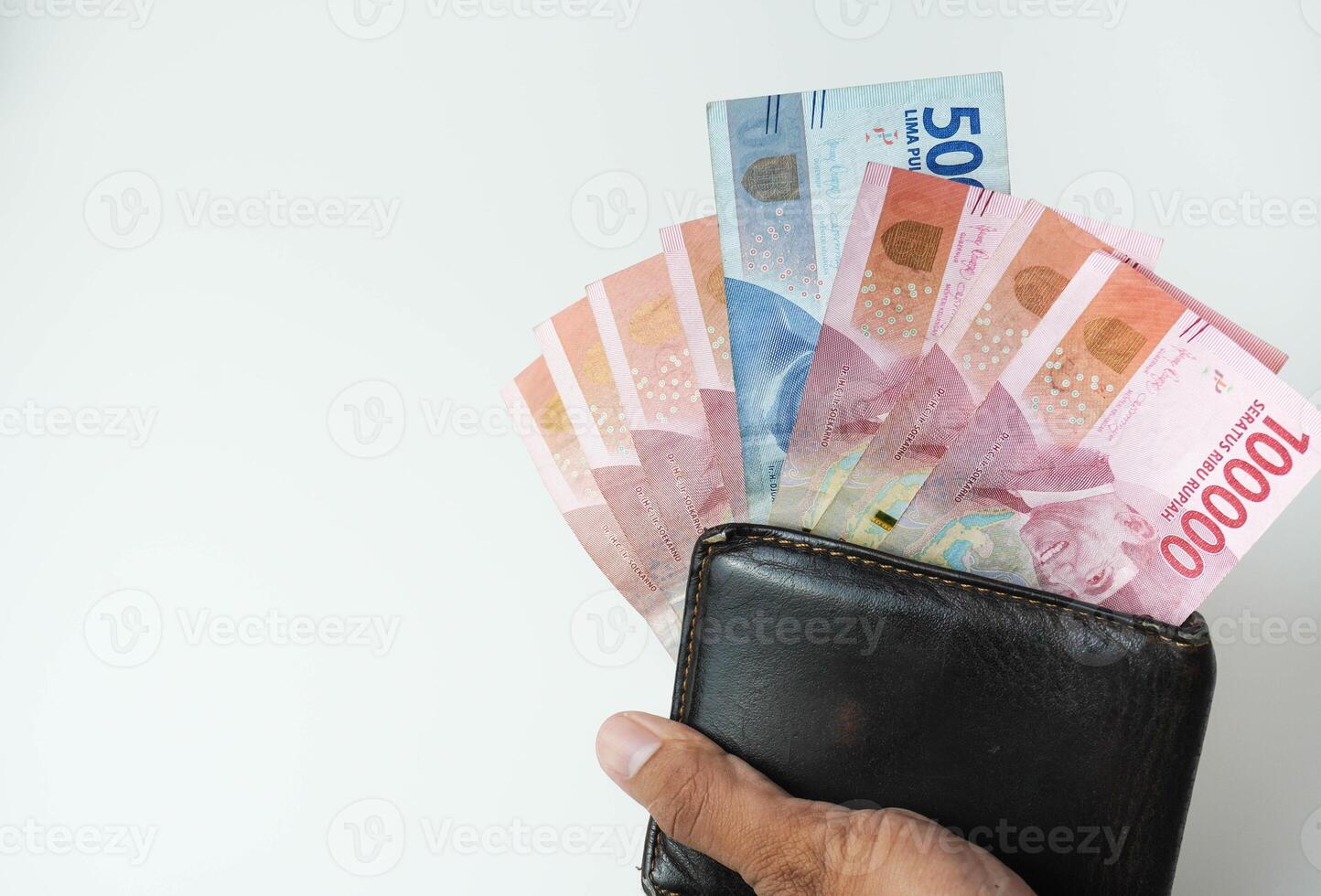 holding a wallet with indonesian money rupiah looking out of the wallet white background photo