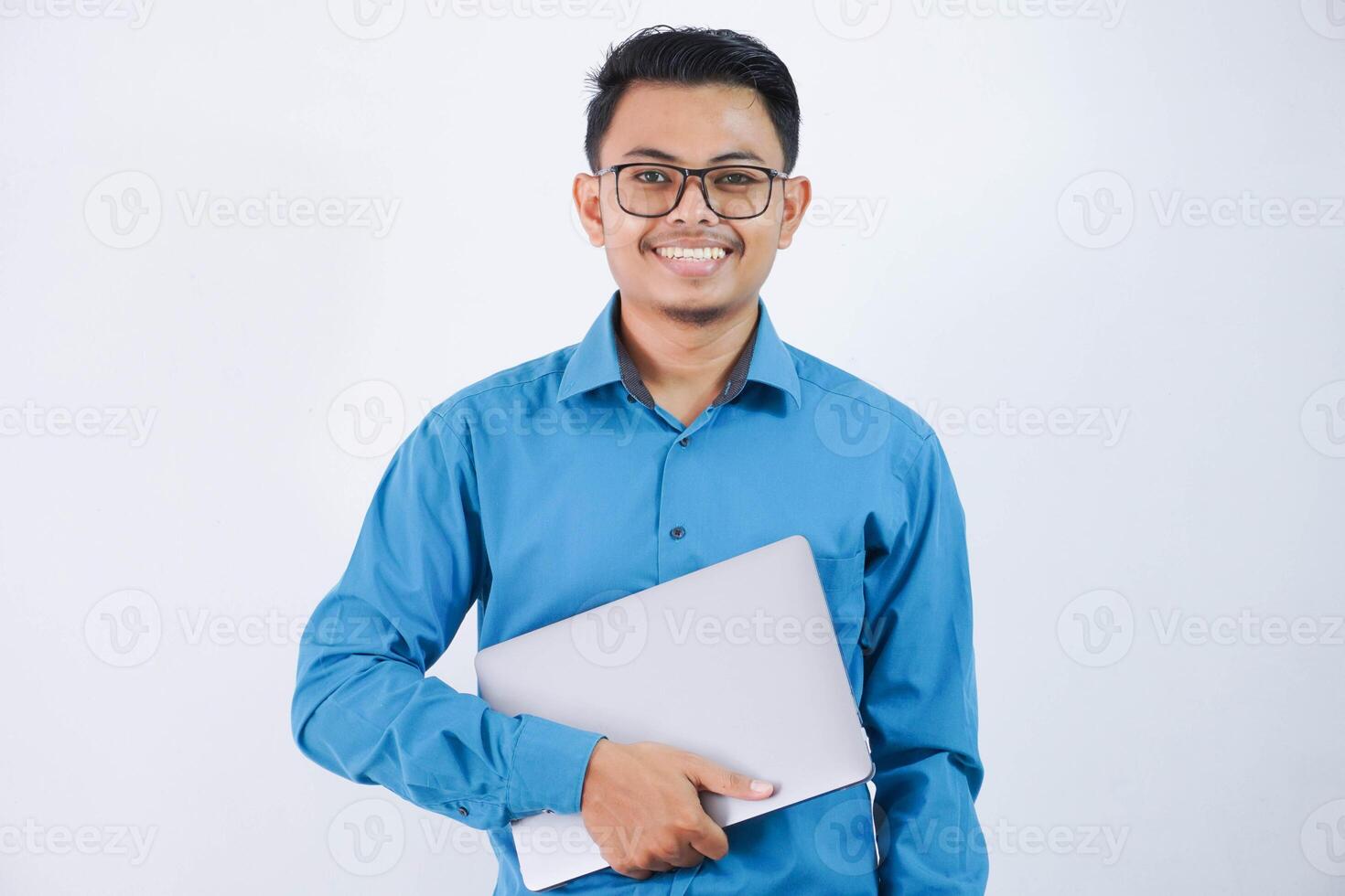 smiling or happy asian businessman with glasses holding laptop wearing blue shirt isolated on white background photo