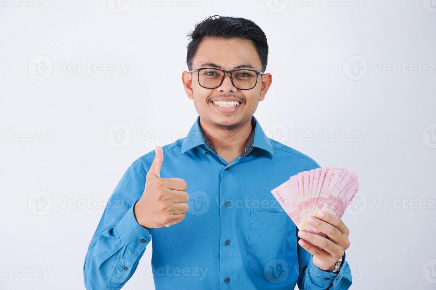 smile or happy asian employee man with glasses holding money wearing blue shirt isolated on white background photo