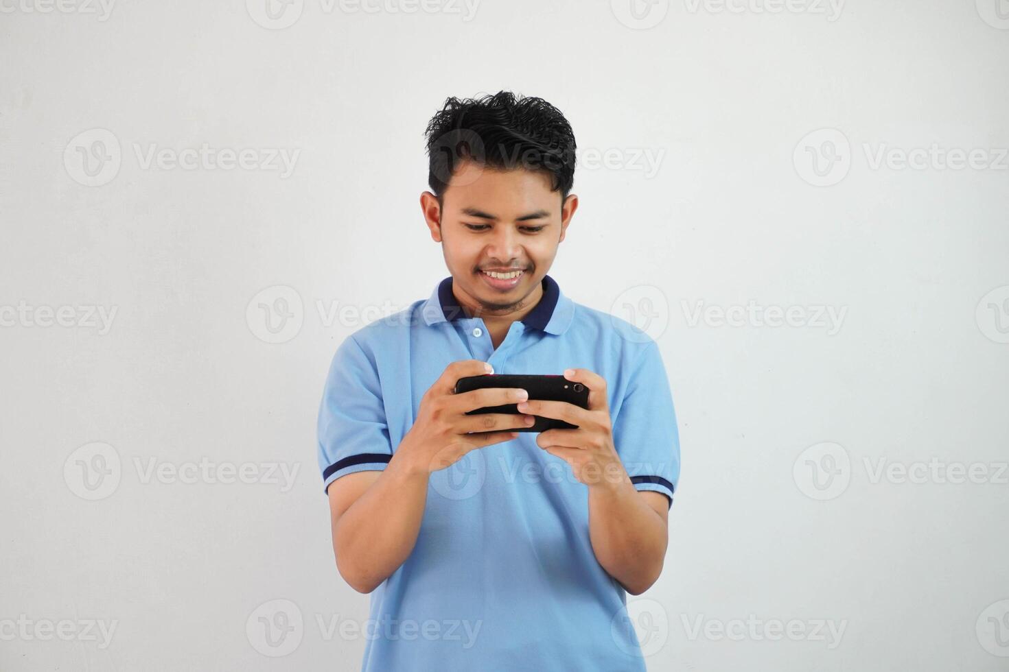 smiling or happy portrait young asian man playing game with smartphone isolated on white background photo