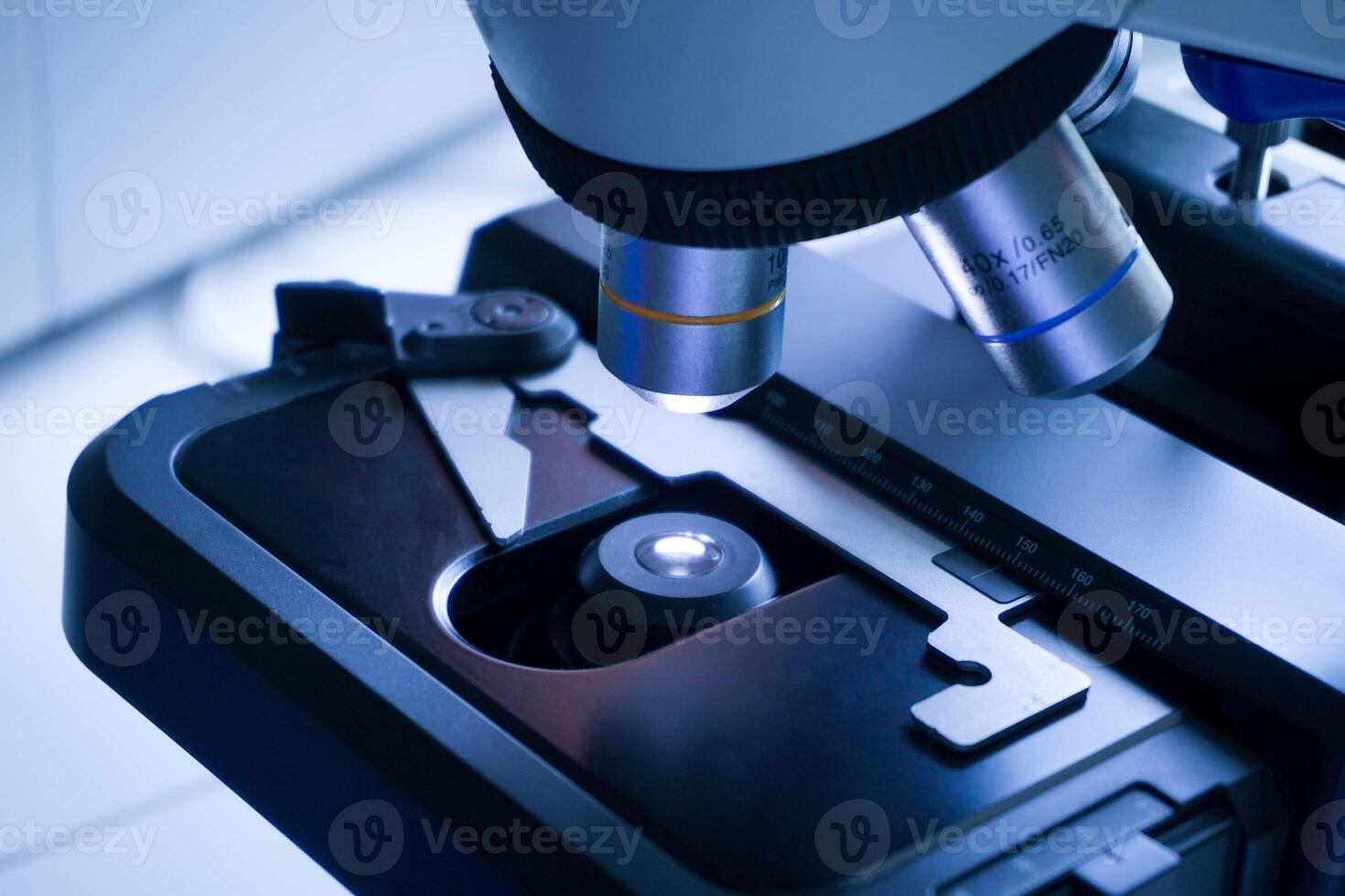 de cerca Disparo de microscopio con metal lente a laboratorio. investigación química equipo alcance biotecnología foto