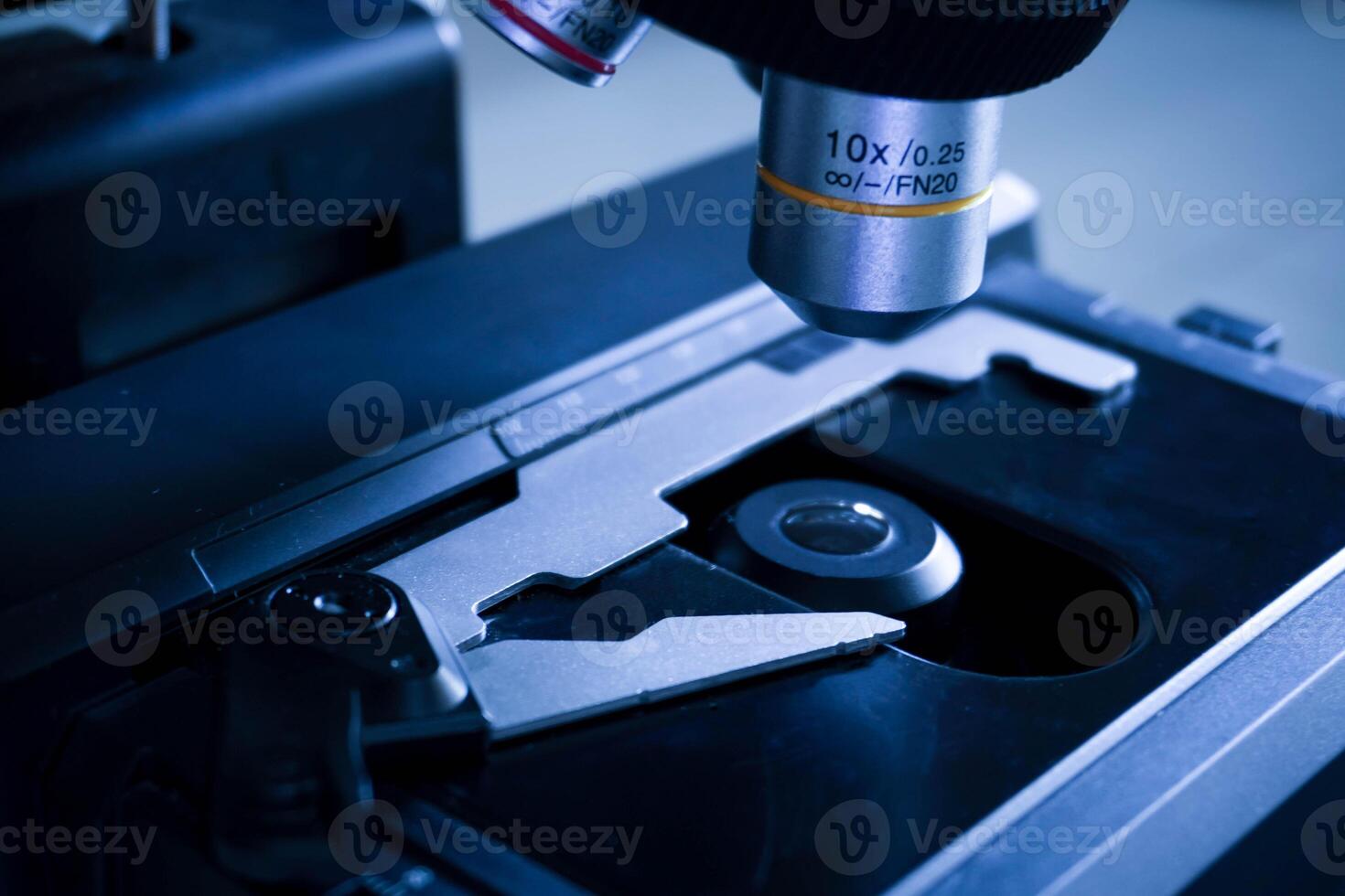 Close-up shot of microscope with metal lens at laboratory. research chemistry equipment scope biotechnology photo