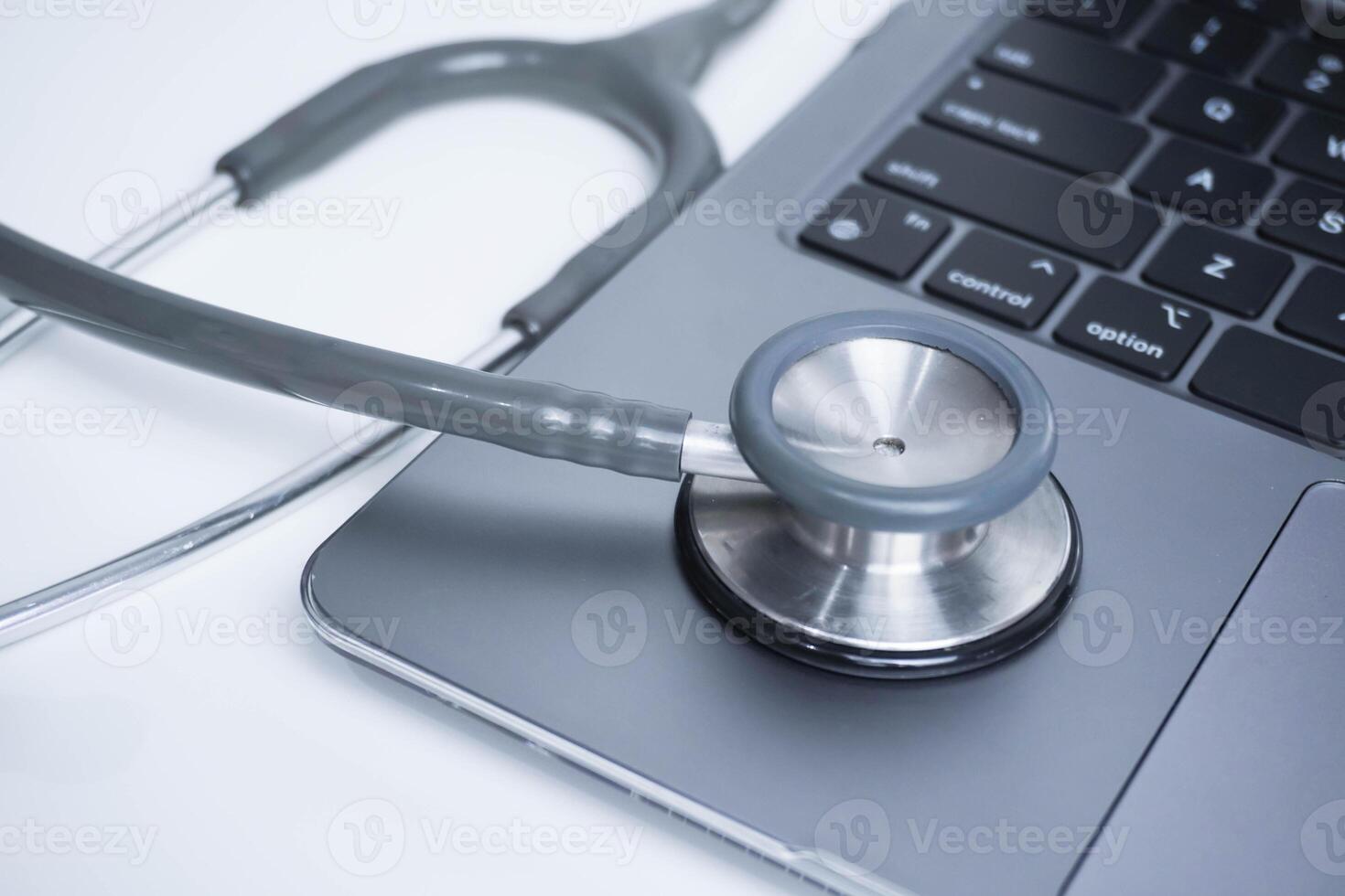 grey Stethoscope on laptop or on the keyboard of pc, close-up. macro view of a grey stethoscope on a business office laptop keyboard with selective focusing effect photo