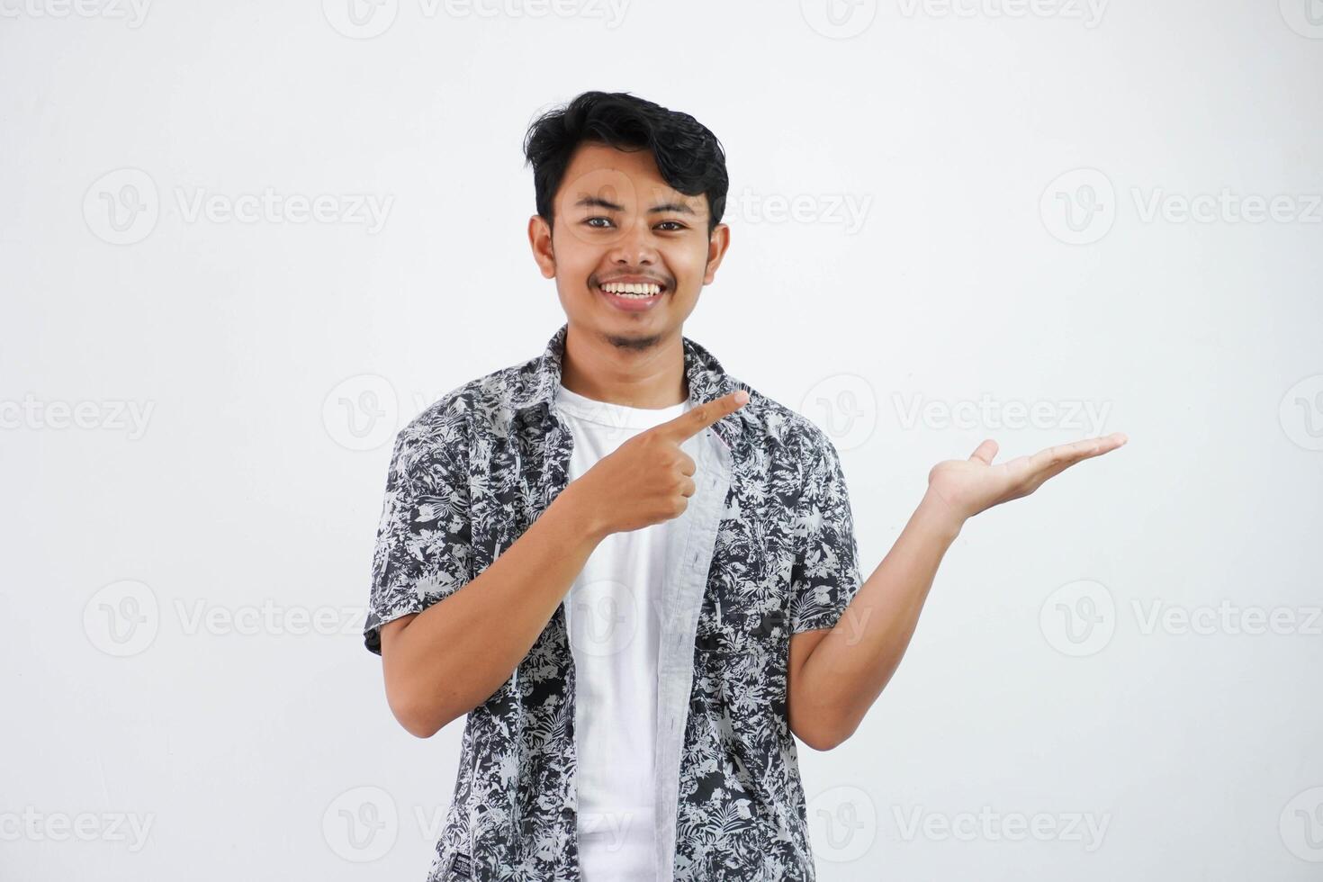 smiling asian man with an open hand with fingers pointing to the side wearing black shirt isolated on white background photo