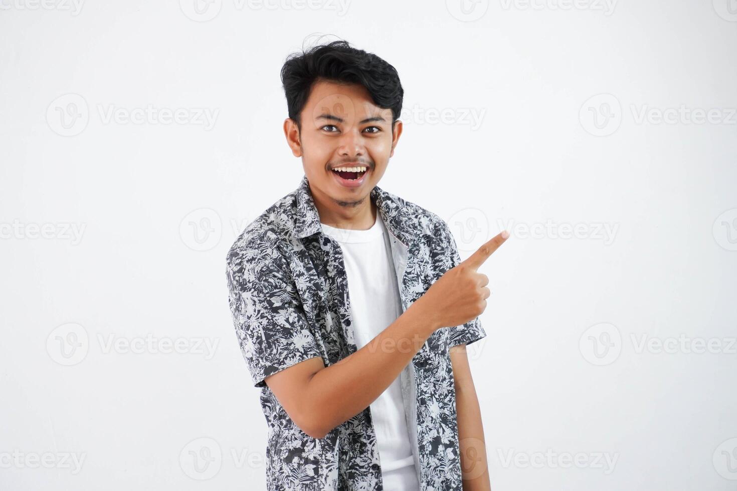 smiling asian man with fingers pointing to the side wearing black shirt isolated on white background photo