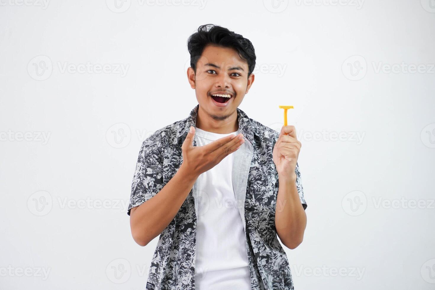 smiling or happy young asian man pointing at the shaver with his finger wearing black shirt isolated on white background photo