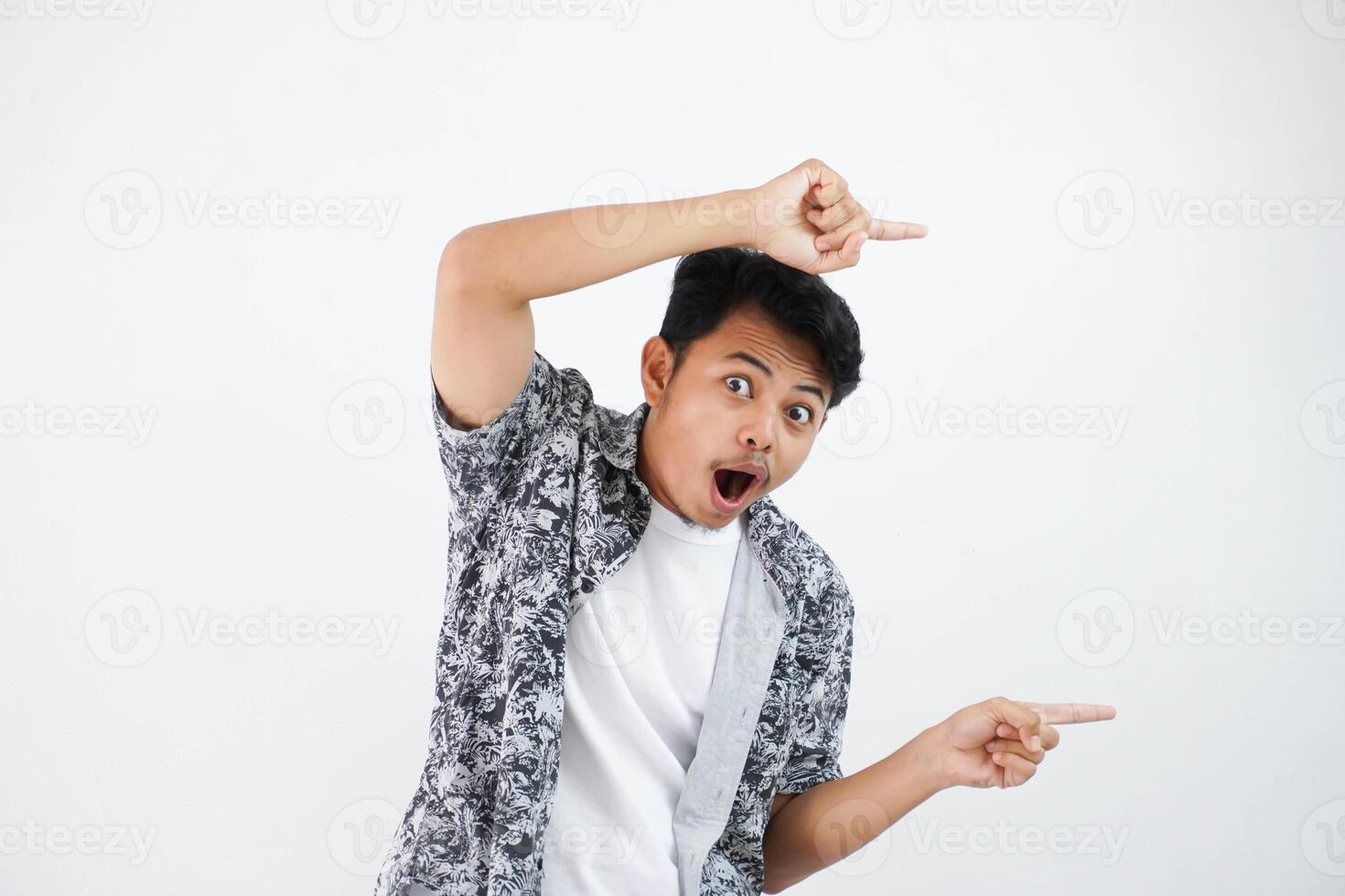 shocked asian man with fingers pointing to the side wearing black shirt isolated on white background photo