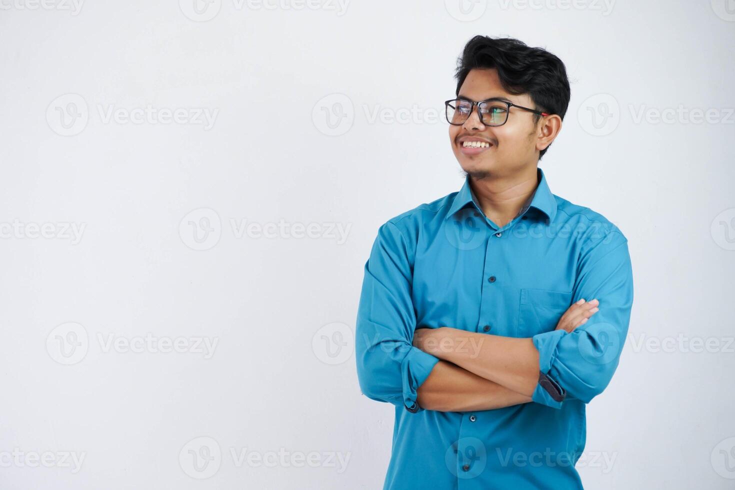 sonrisa o contento asiático empresario con lentes cruzado brazos y mirando cámara vistiendo azul camisa aislado en blanco antecedentes foto
