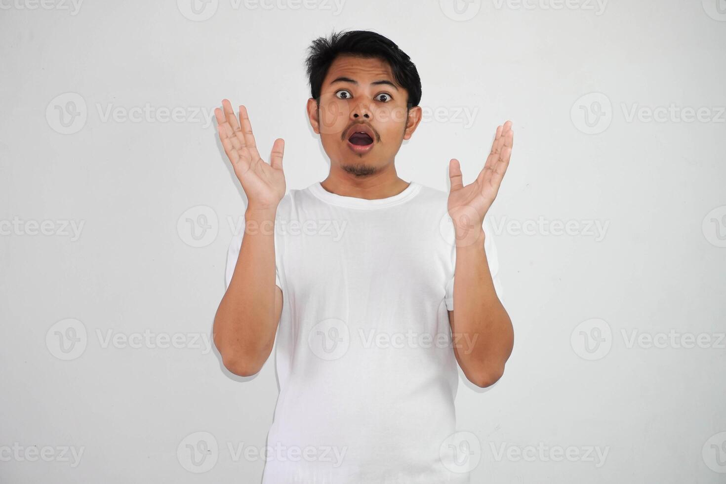 shock asian man with open hands and mouth wearing white t shirt isolated on white background photo