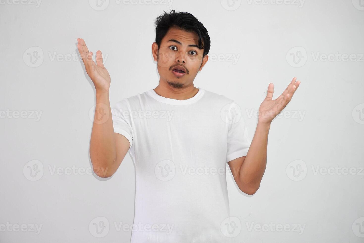 shock asian man with open hands and mouth wearing white t shirt isolated on white background photo