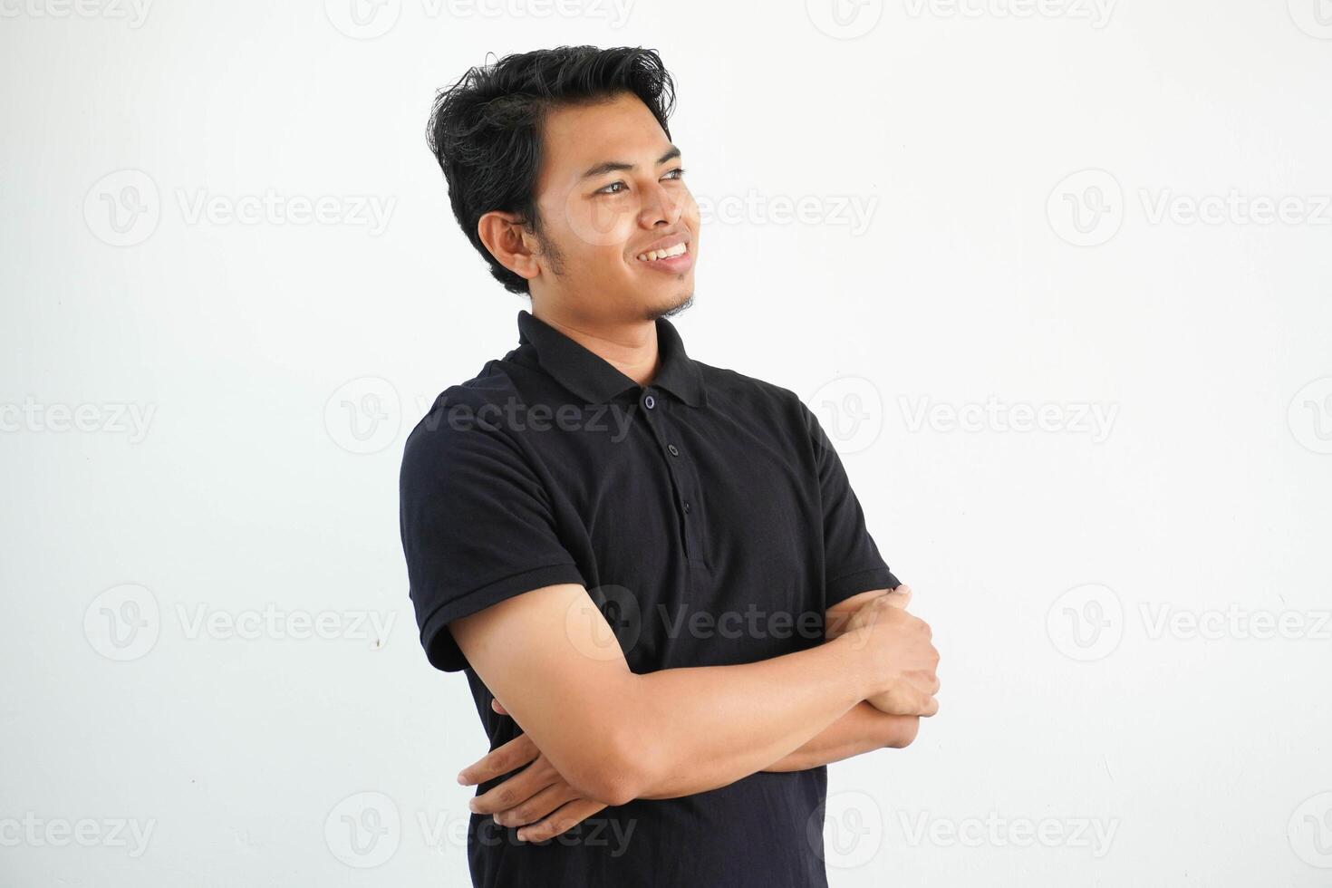 sonriente actitud joven asiático hombre mirando a el arriba lado vistiendo negro polo t camisa aislado en blanco antecedentes foto