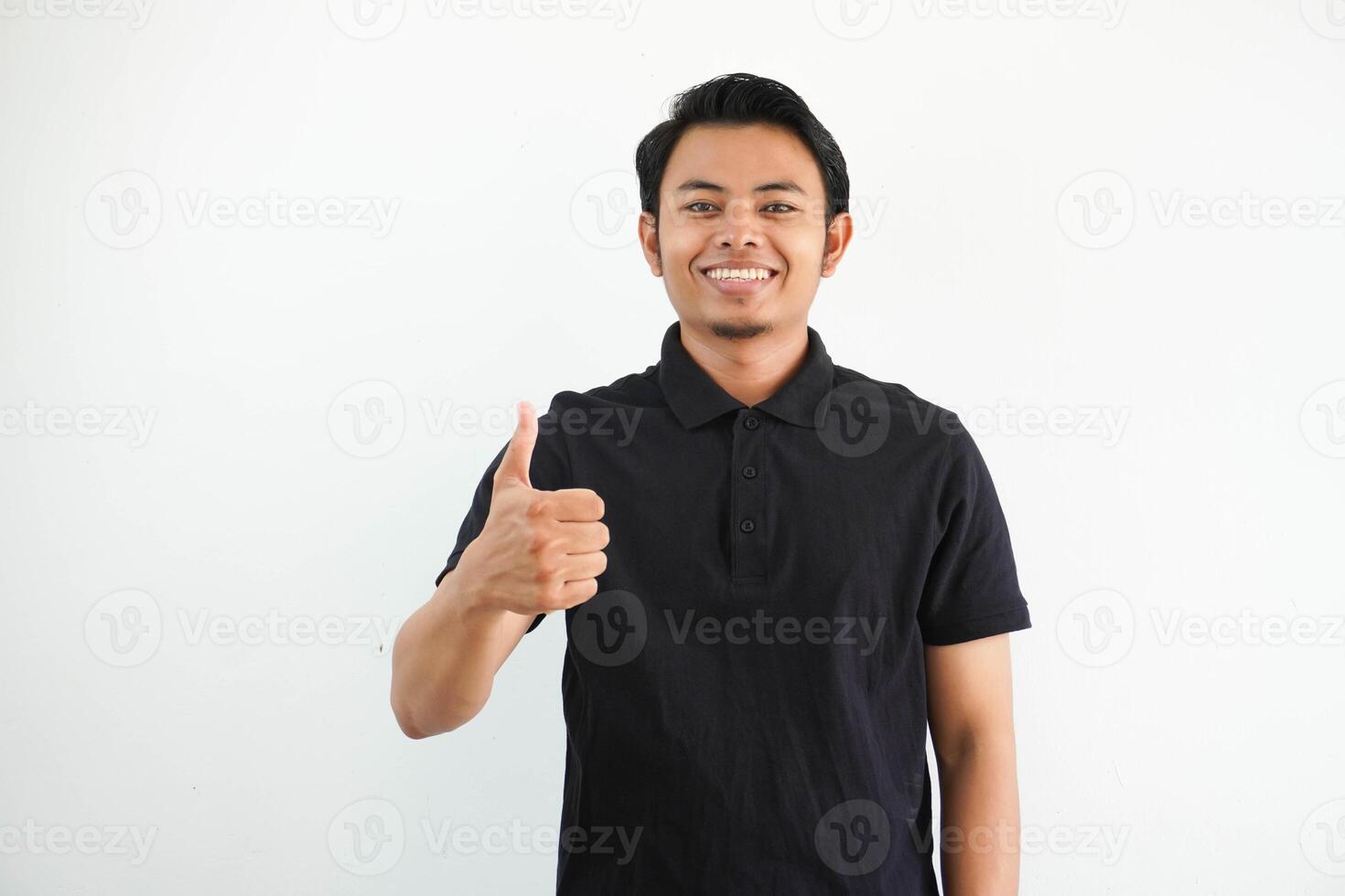 portrait of smiling young Asian man give thumb up wearing black polo t shirt isolated on white background photo