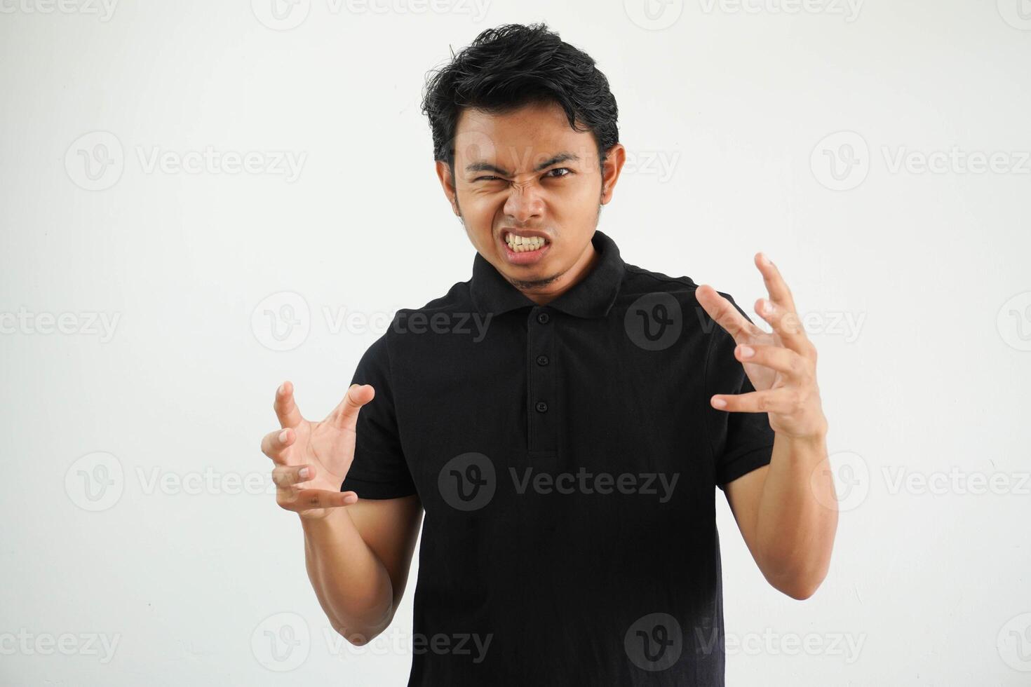 Portrait of angry pensive crazy Asian young man screaming wearing black polo t shirt isolated on white background photo