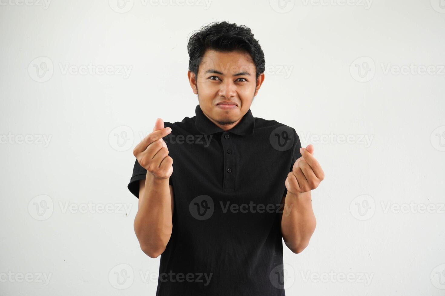 sonriente o contento asiático hombre demostración gesto corazón forma manos o cruce su índice dedo y pulgar el símbolo saranghae, sarangheo, saranghaeo vistiendo negro polo t camisa aislado foto