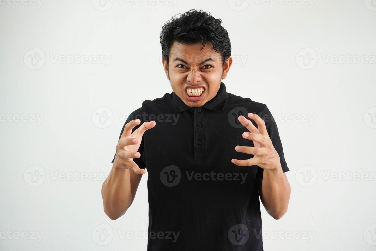 Portrait of angry pensive crazy Asian young man screaming wearing black polo t shirt isolated on white background photo