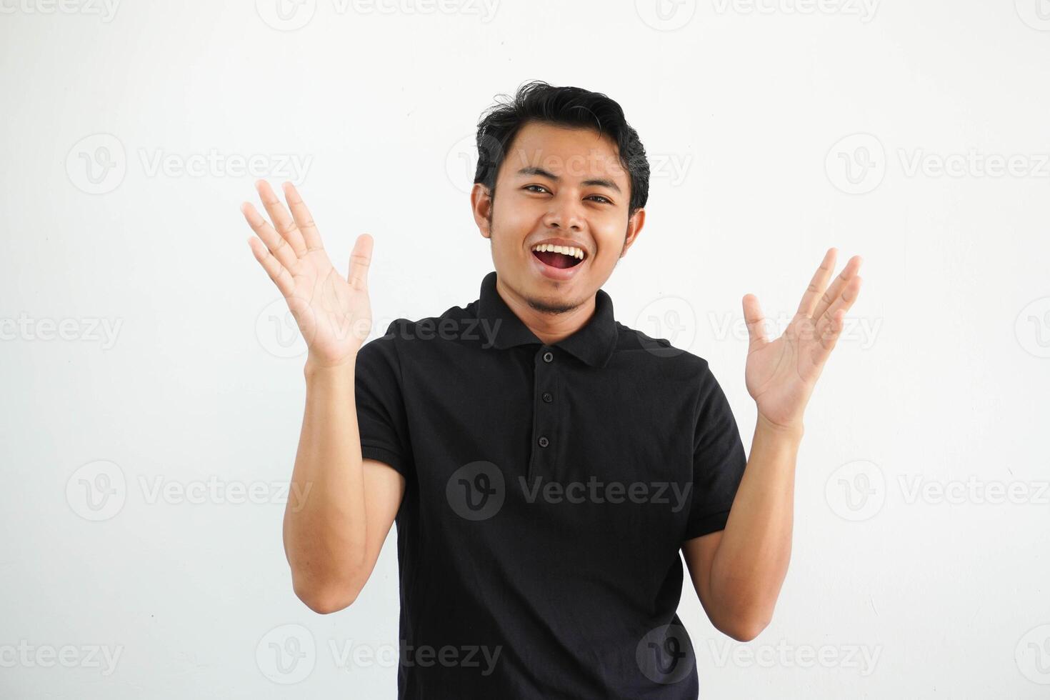 happy young Asian man wearing black polo t shirt isolated on white background celebrating a victory or success, he is surprised and shocked. photo