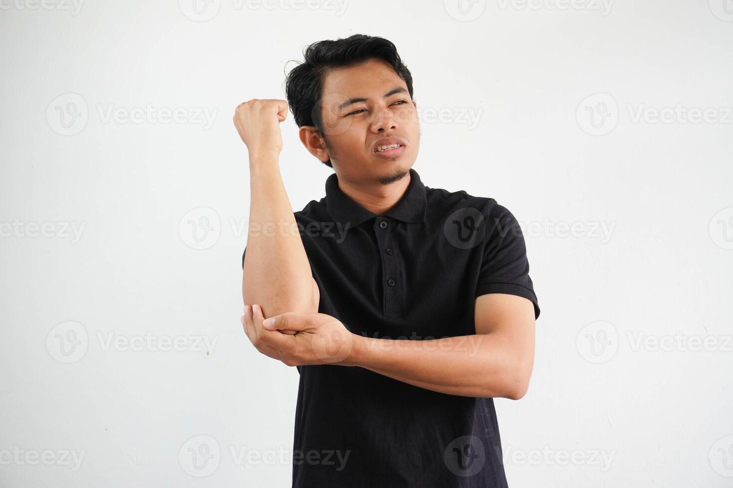 joven asiático hombre masajear codo, sufrimiento después un malo movimienot, vistiendo negro polo t camisa aislado en blanco antecedentes foto