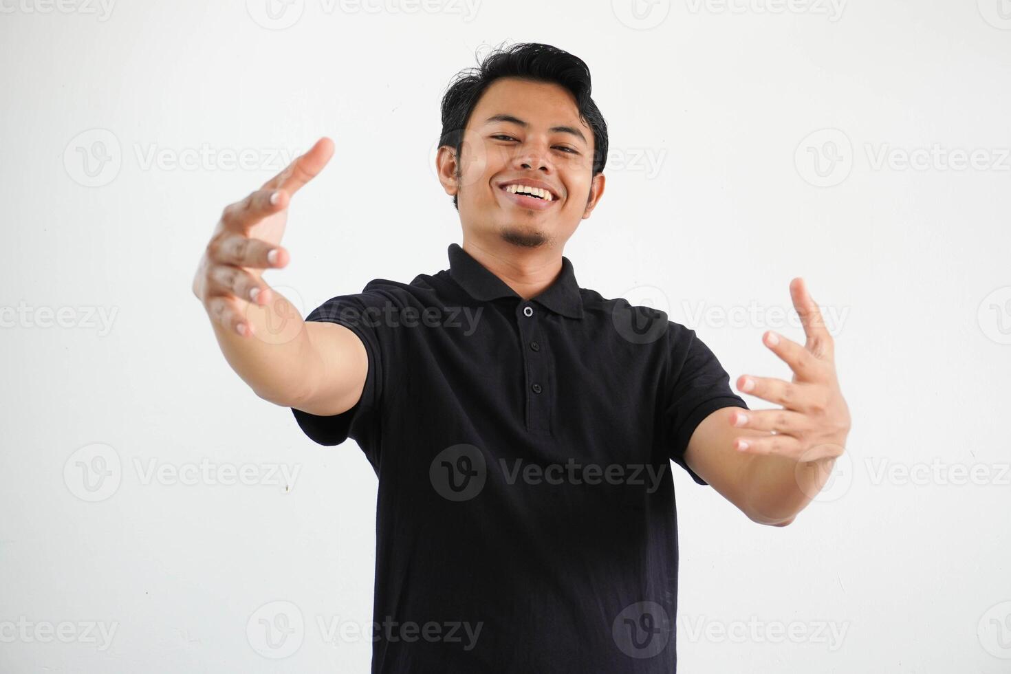 joven asiático hombre siente confidente dando un abrazo a el cámara, vistiendo negro polo t camisa aislado en blanco antecedentes foto