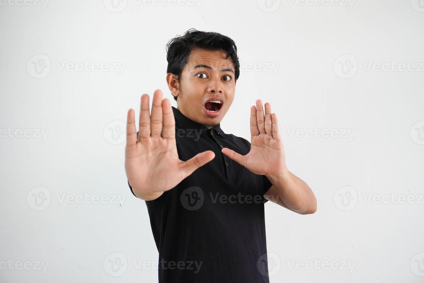 young asian man, being shocked due to an imminent danger wearing black polo t shirt isolated on white background photo