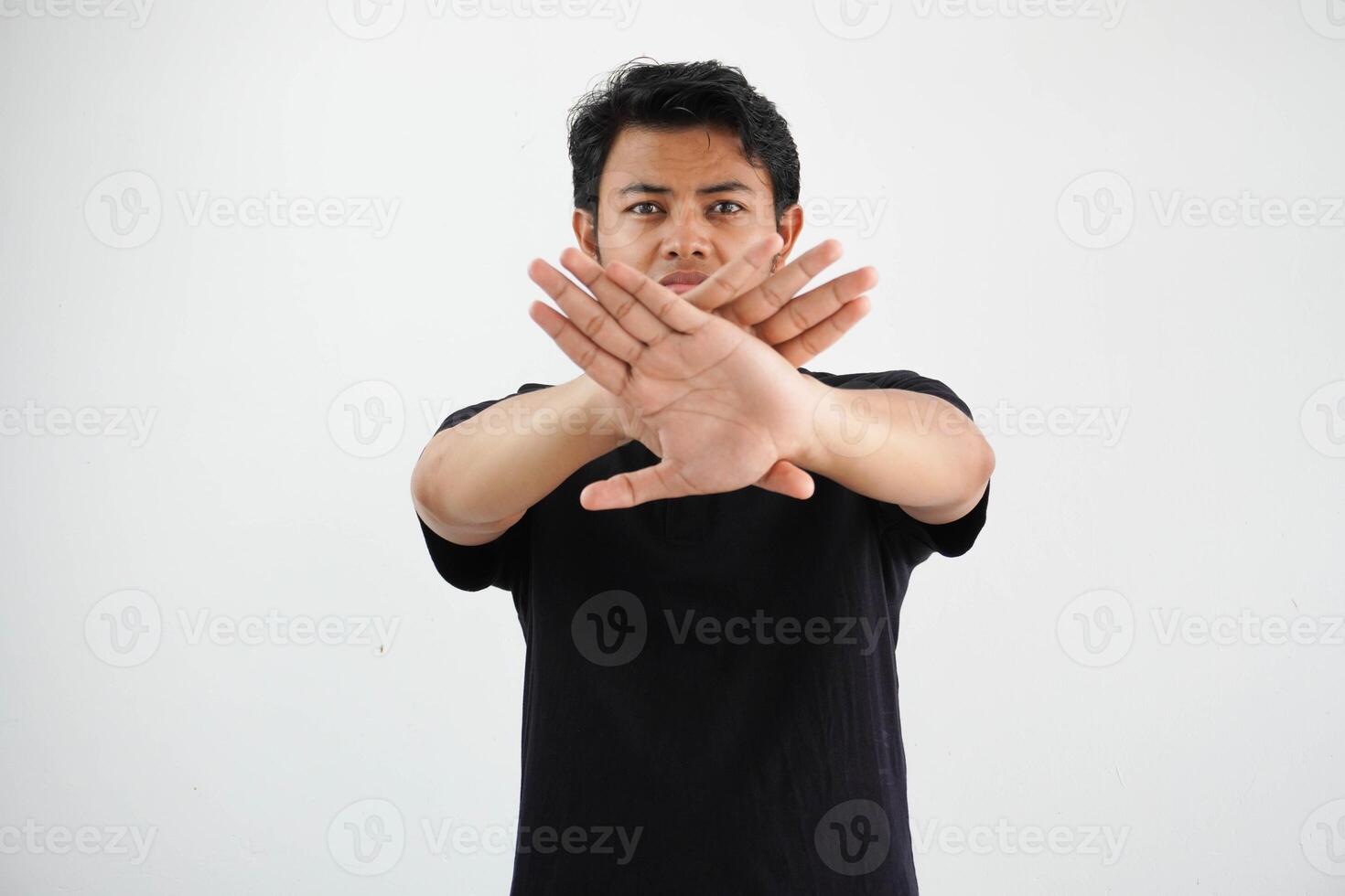 young asian man making stop gesture with her hand to stop an act wearing black polo t shirt isolated on white background photo