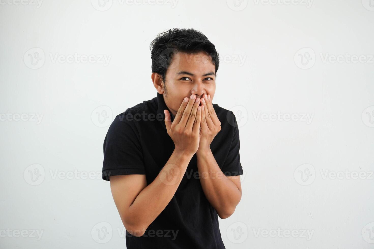 smiling Young asian man isolated on white background Embarrassed, covering mouth with hands wearing black polo t shirt. photo