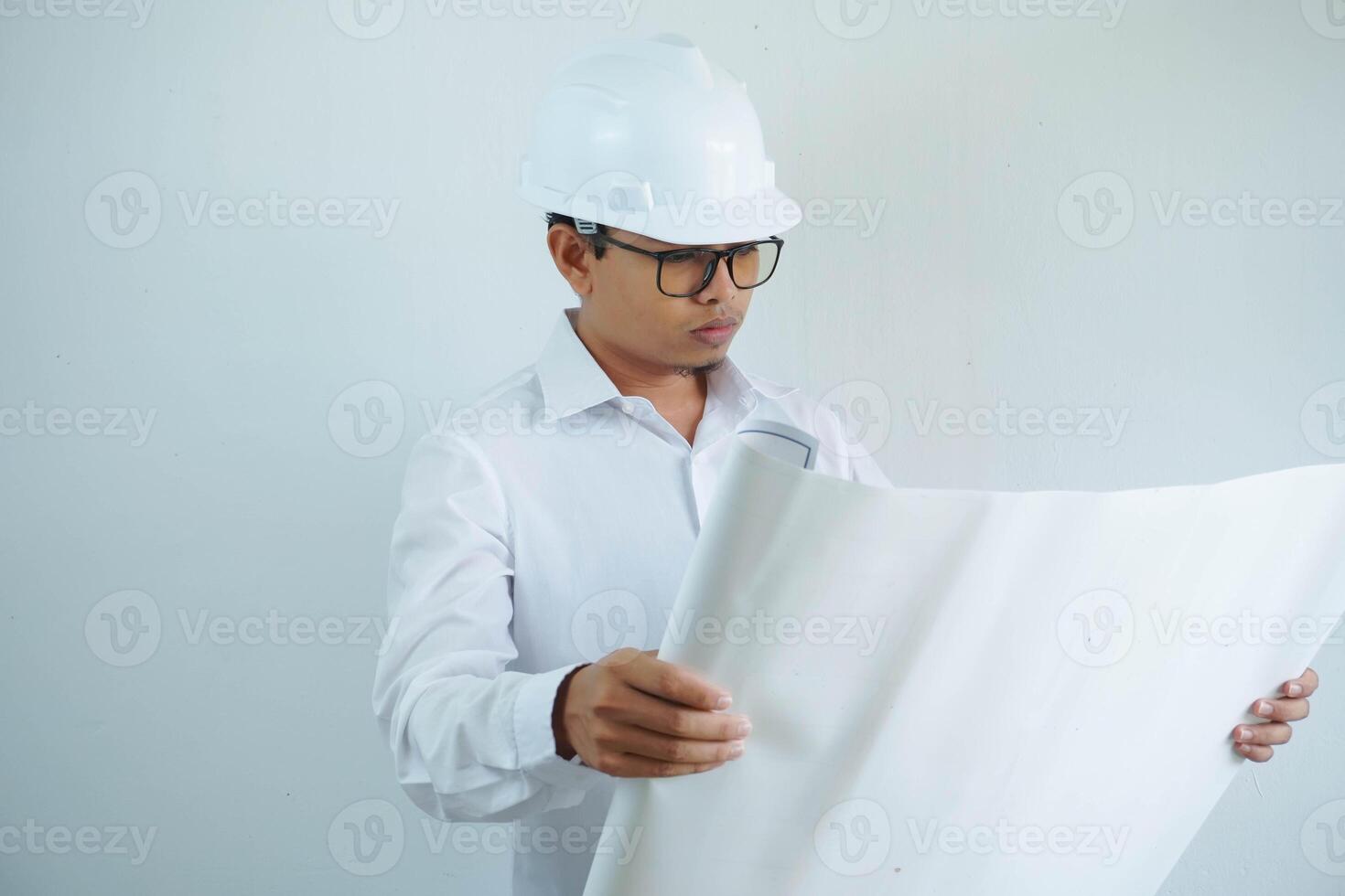 young asian male architect engineer smiling and Holding engineering blueprints isolated on white background. photo