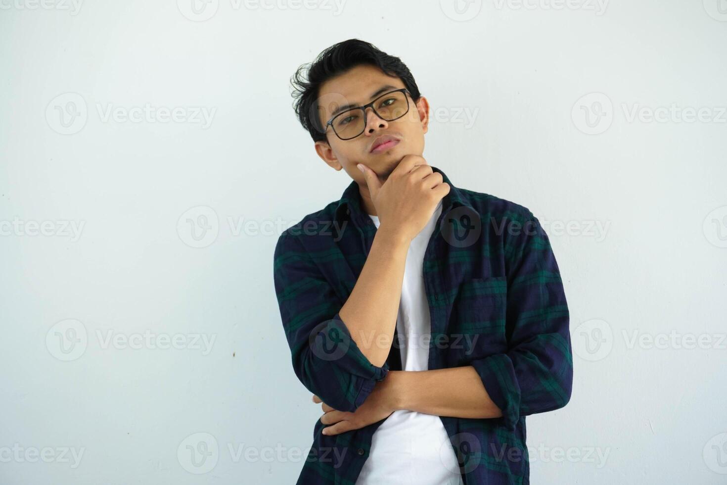 young asian man showing gloomy expression with hand holding chin isolated on white background photo