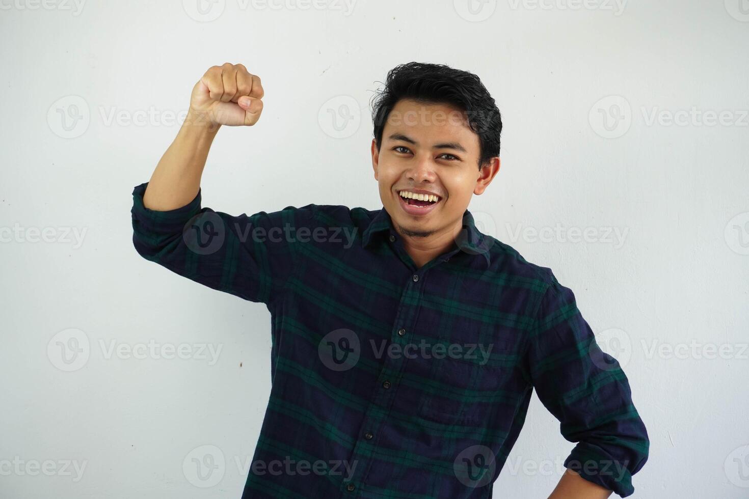 young asian man screaming success with his fist clenched isolated on white background photo