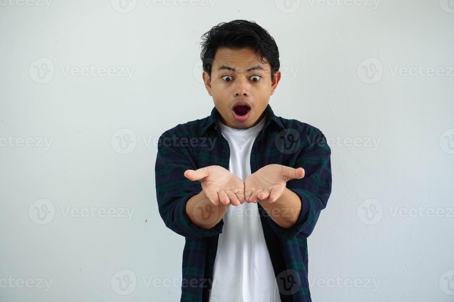 joven asiático hombre conmocionado con ambos mano haciendo dando alguna cosa actitud aislado en blanco antecedentes. foto