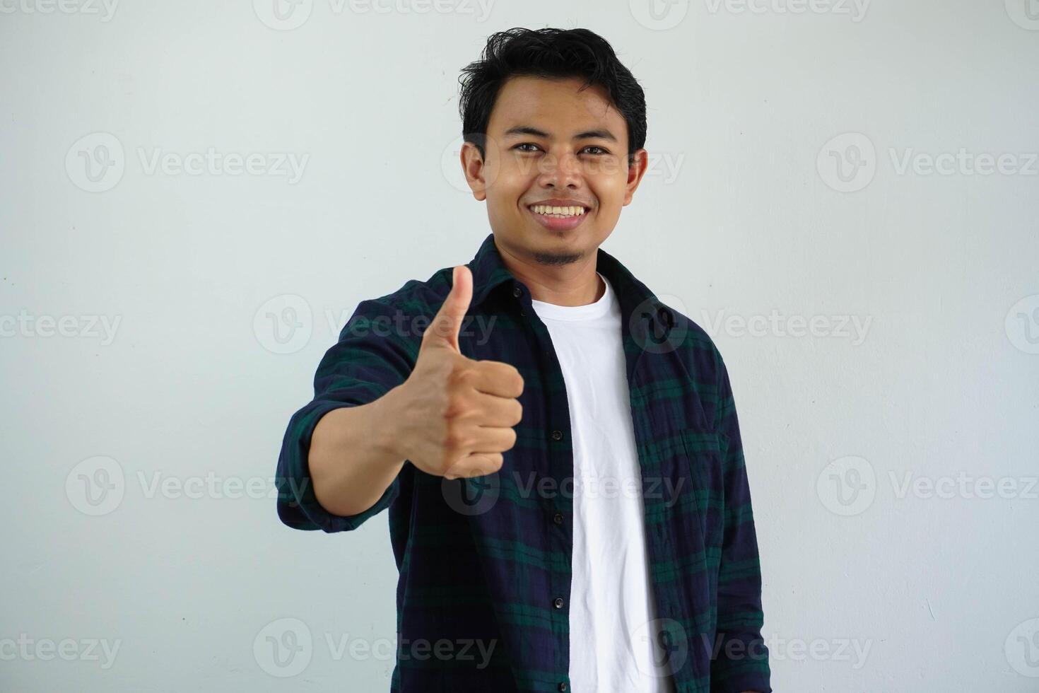 young asian man smiling happy at the camera and give thumb up isolated on white background. photo