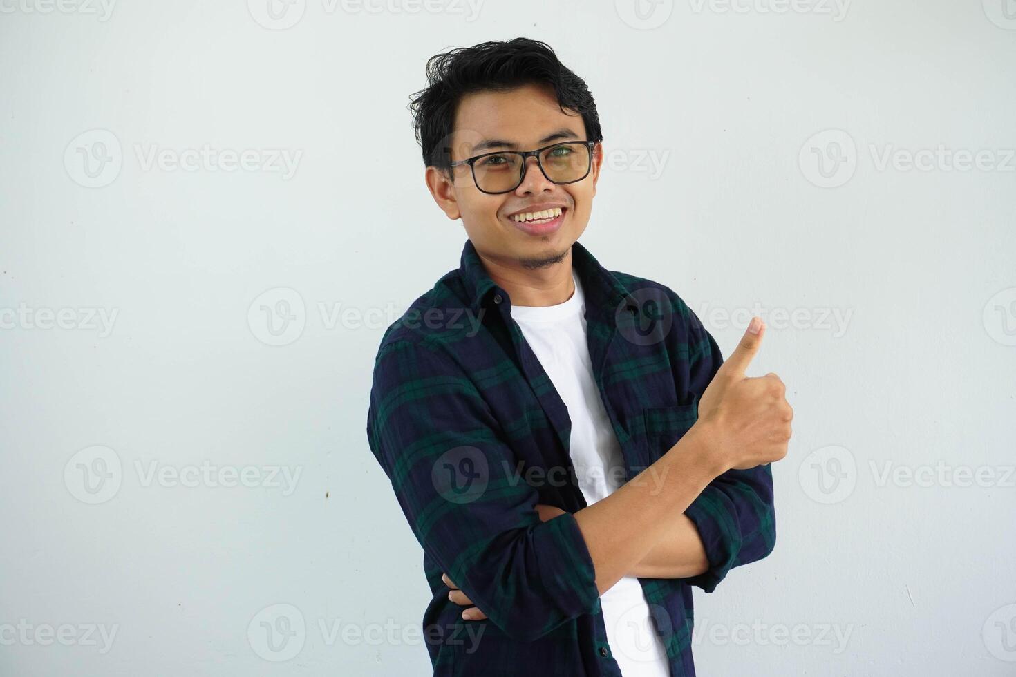 young asian man smiling happy at the camera and give thumb up isolated on white background. photo