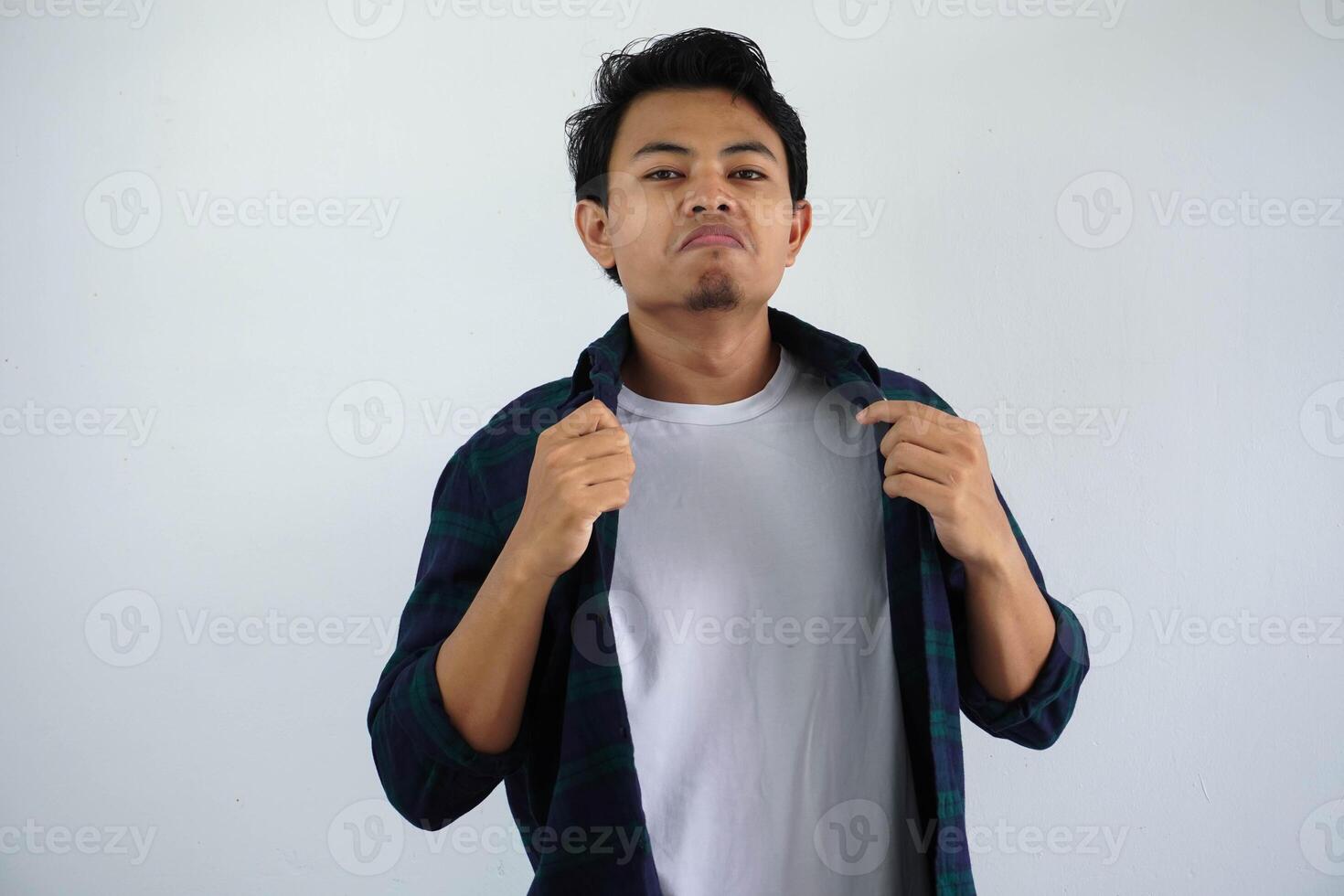 Young Asian man showing arrogant gesture while touching his shirt isolated on white background. photo