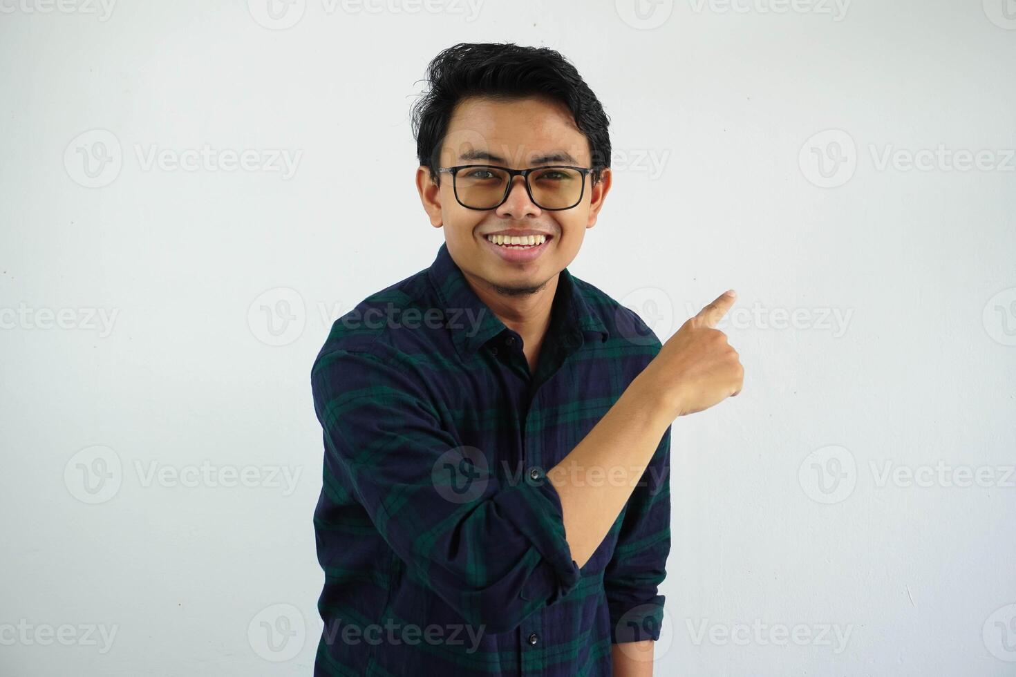 Side view of young Asian man smiling showing happy expression while pointing his behind isolated on white background photo