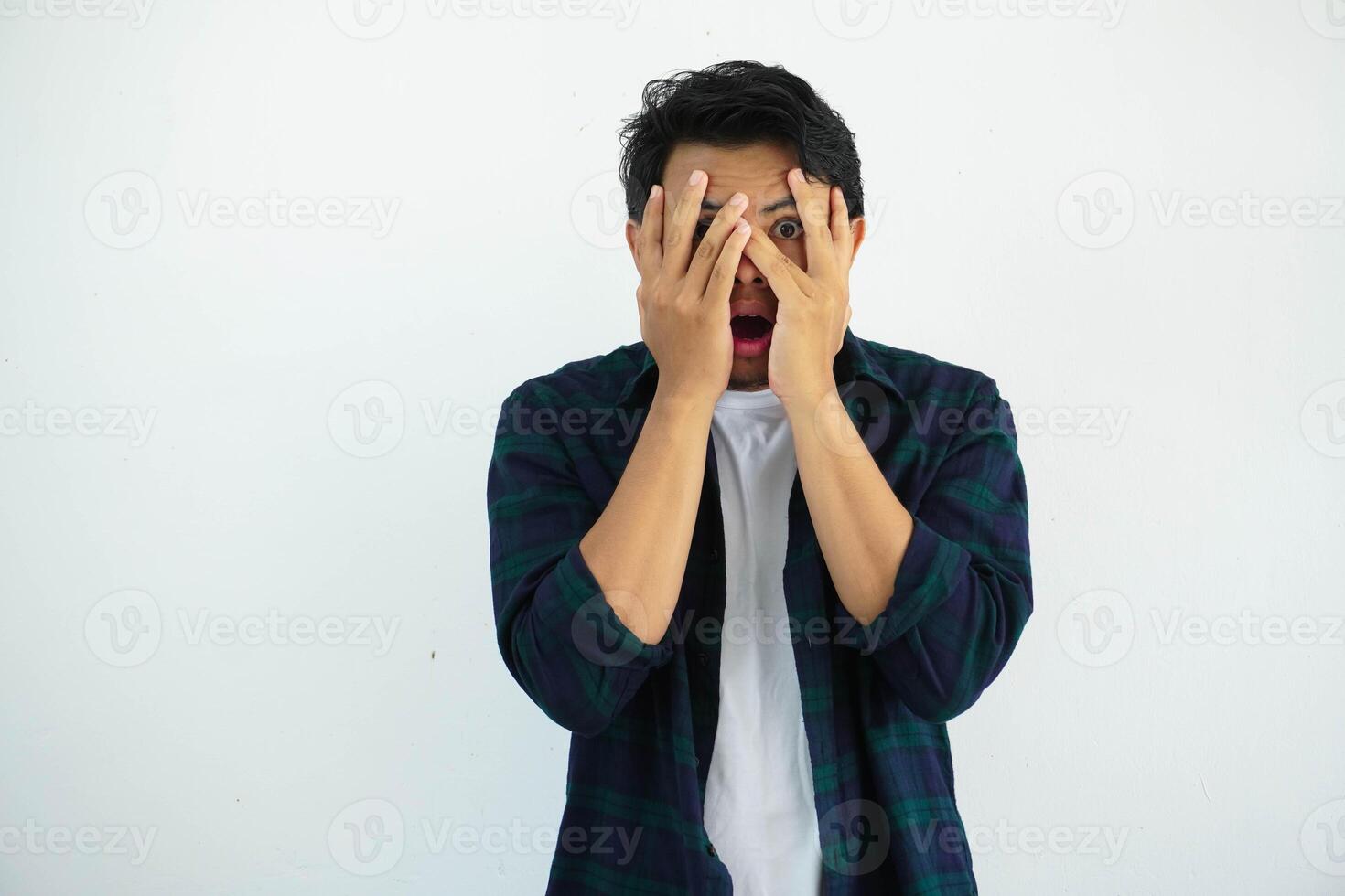 young asian man posing scared and afraid with hands covering face isolated on white background photo