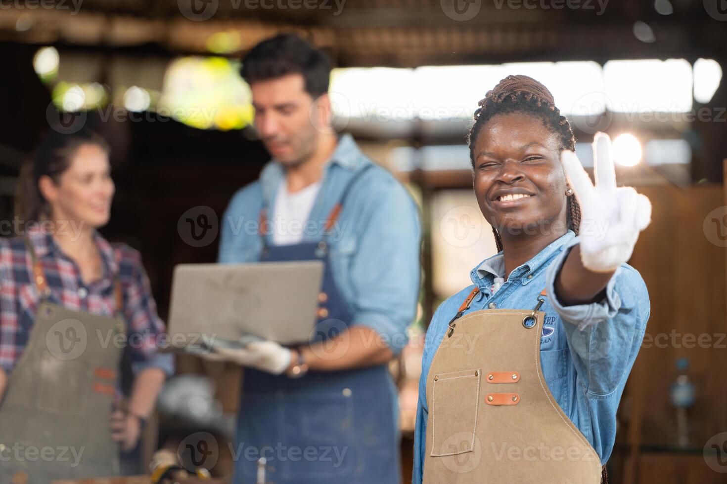 retrato de carpintero hembra trabajador en pie en frente de colega en taller foto