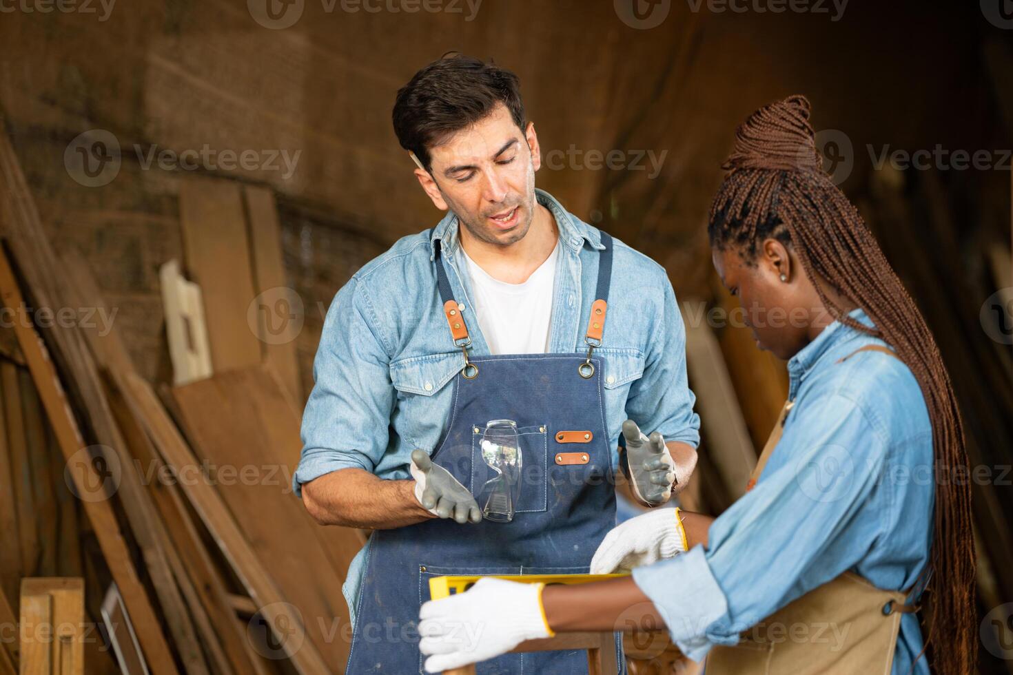 Carpenter and his assistant working together in a carpentry workshop photo