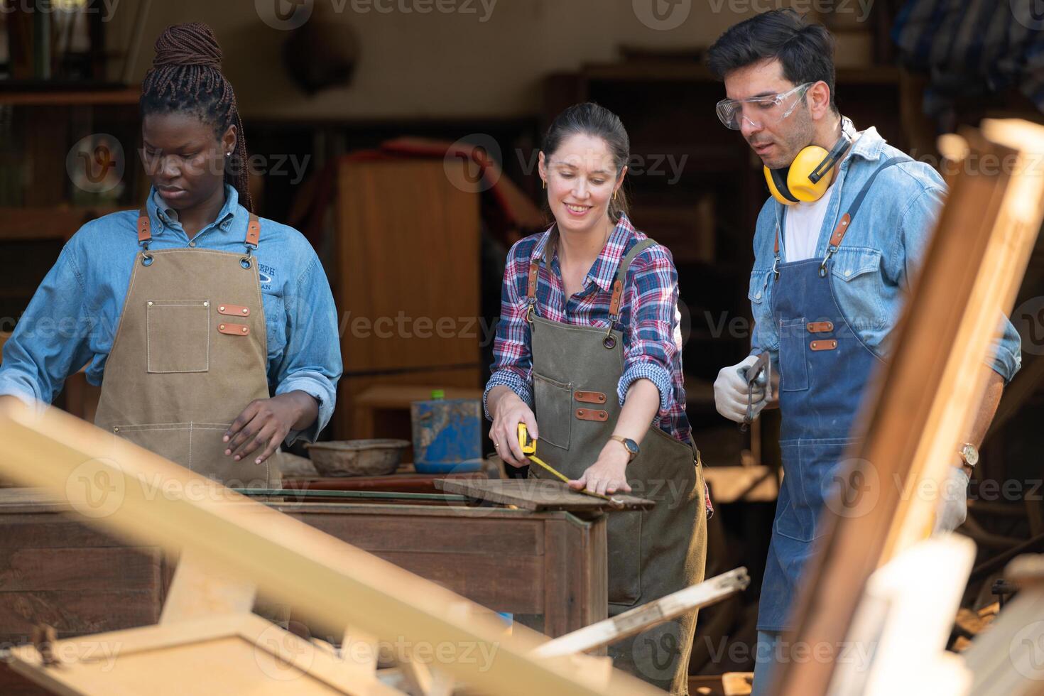 Carpenter and his assistant working together in a carpentry workshop photo